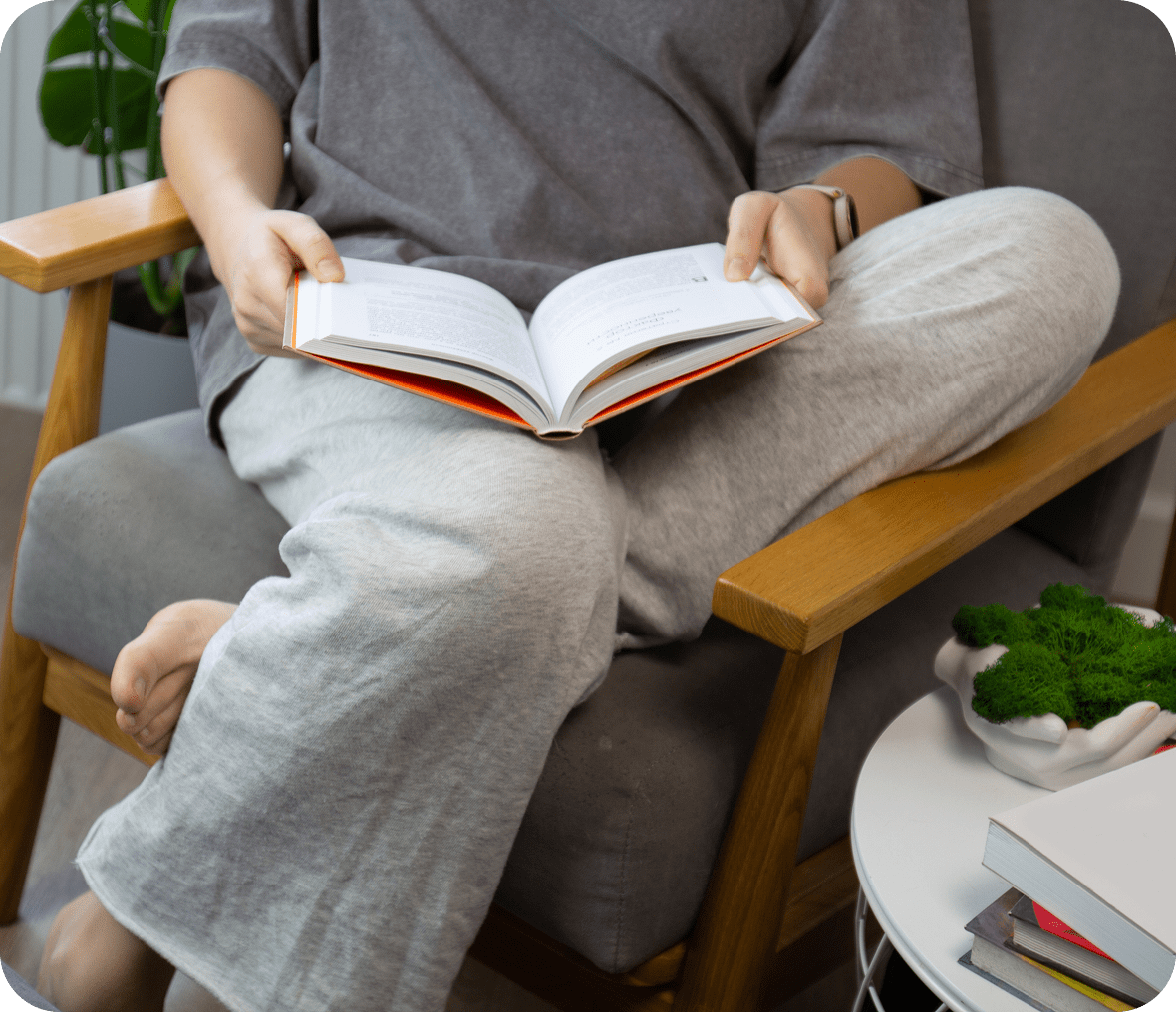 Person reading book on a chair